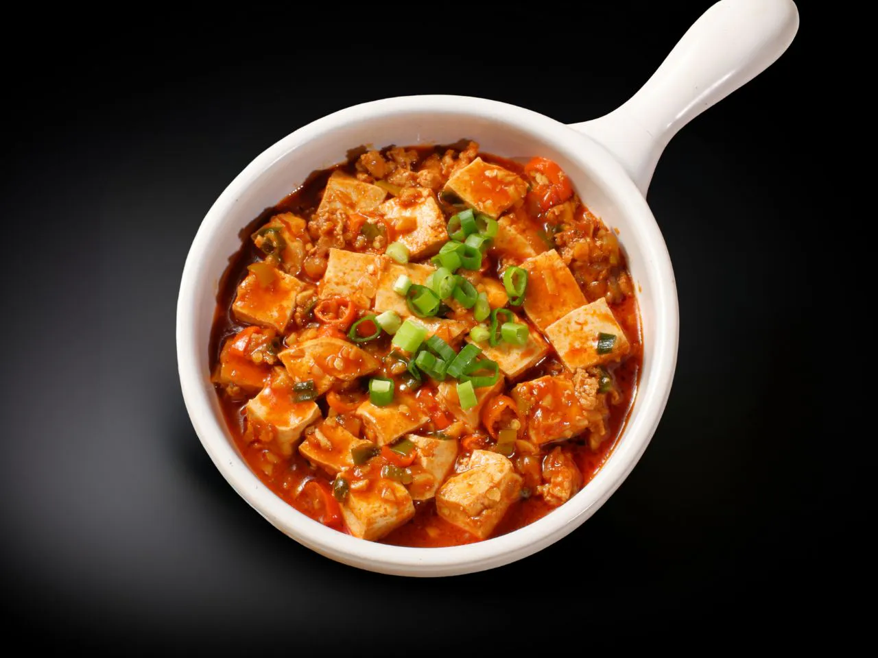 Spicy mapo tofu with minced meat topped with chopped green scallions