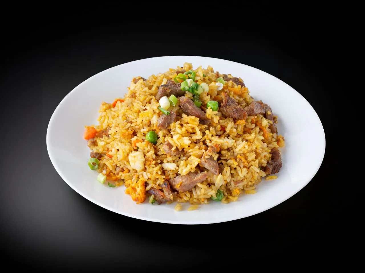 Beef fried rice tossed with peas, carrot, egg and chopped green onions